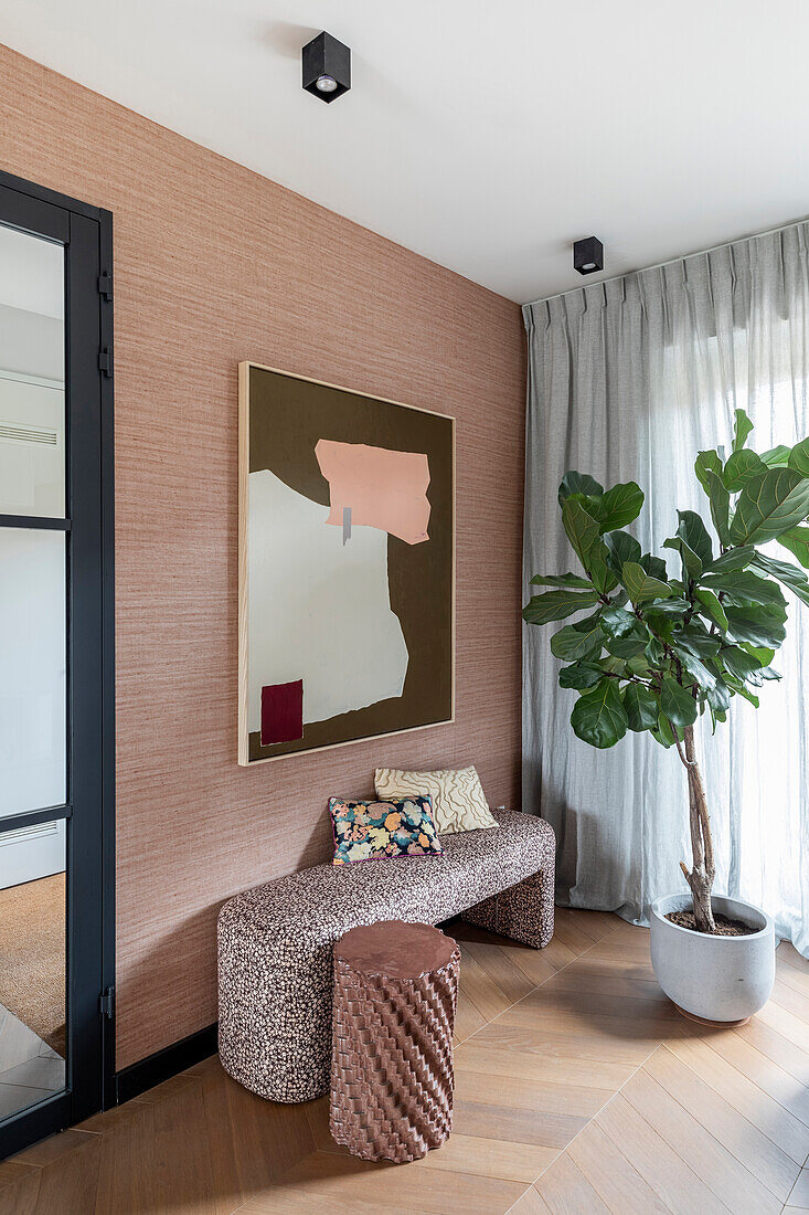 Abstract painting above upholstered bench in modern hallway