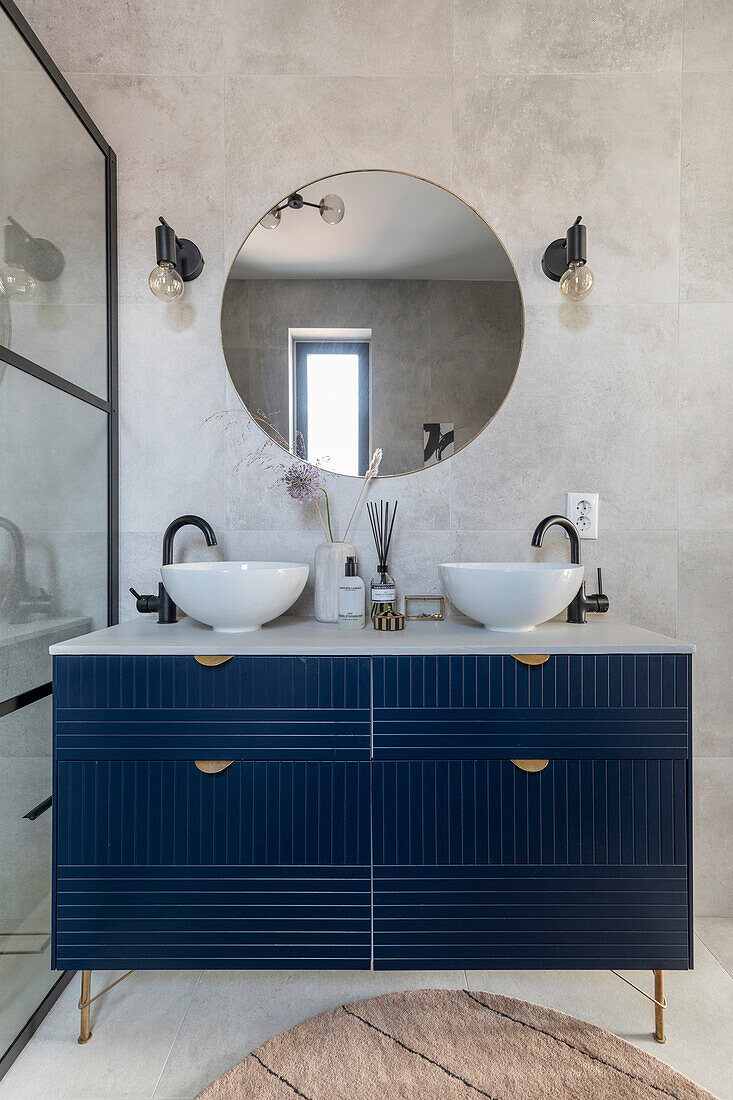 Modern bathroom with double washbasin and dark blue drawer fronts