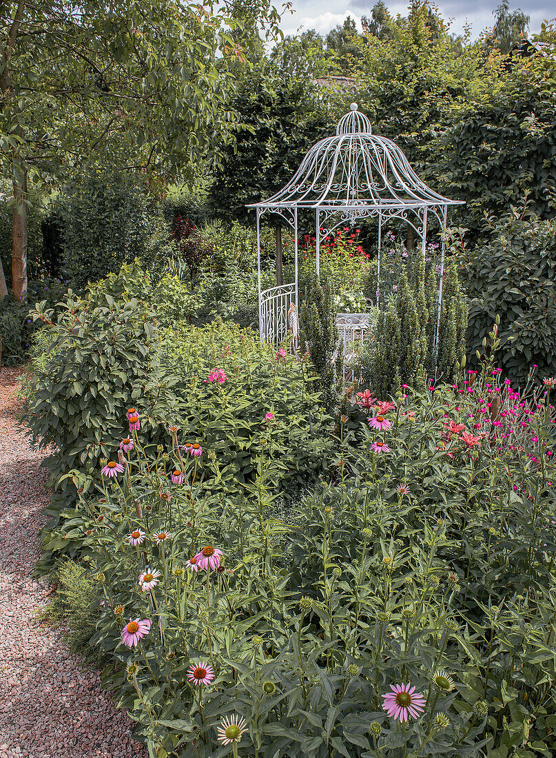 Romantic garden pavilion surrounded by flowering shrubs