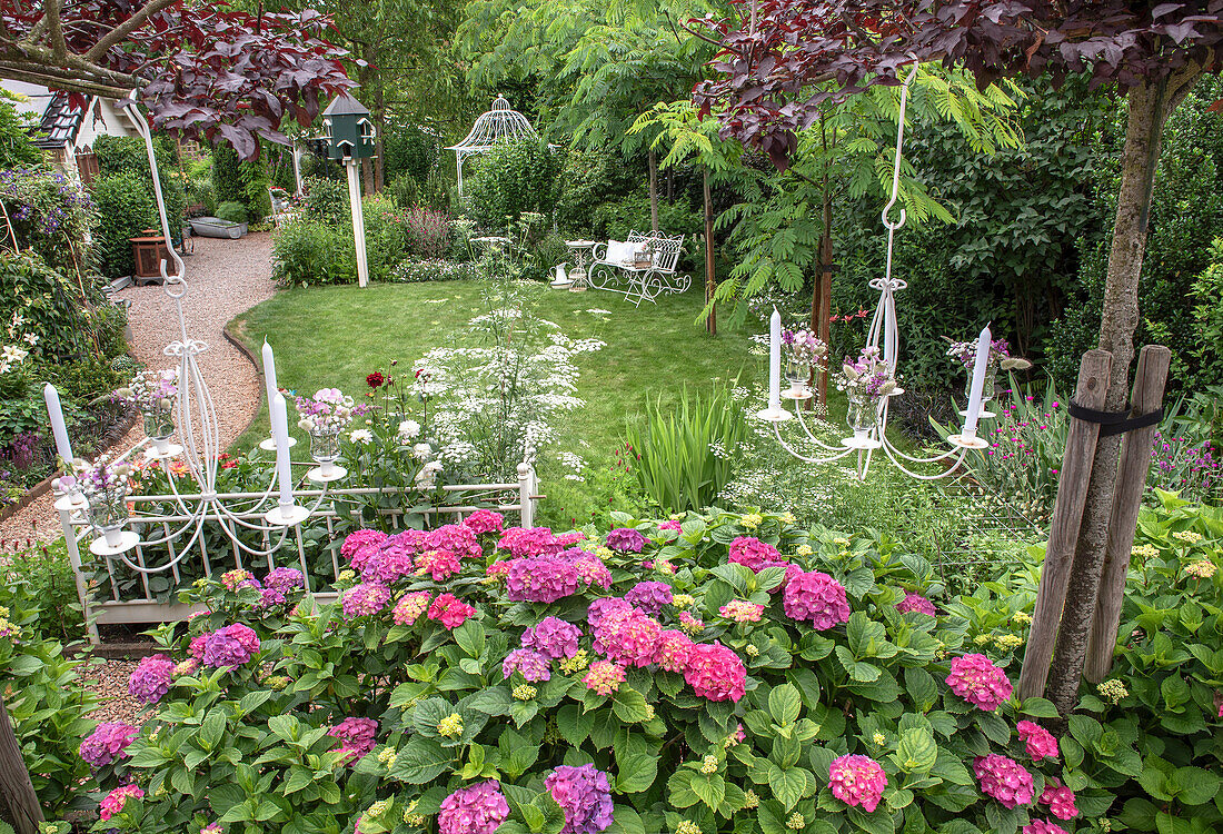 Romantic garden with hydrangeas and hanging chandeliers