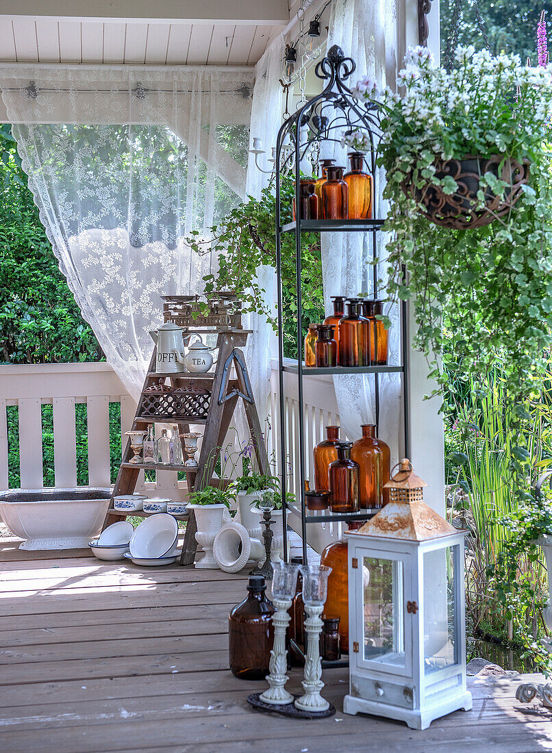 Veranda with decorative glass bottles, crockery, lanterns and candle holders