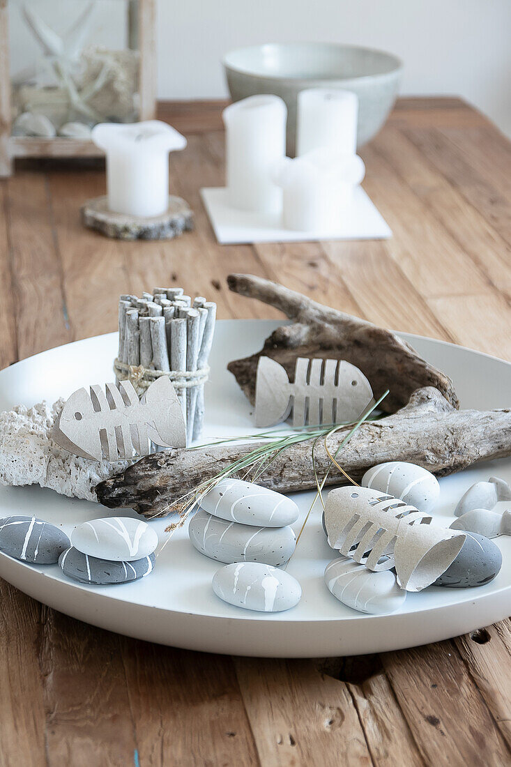 Maritime table decoration with driftwood, painted stones and cardboard fish