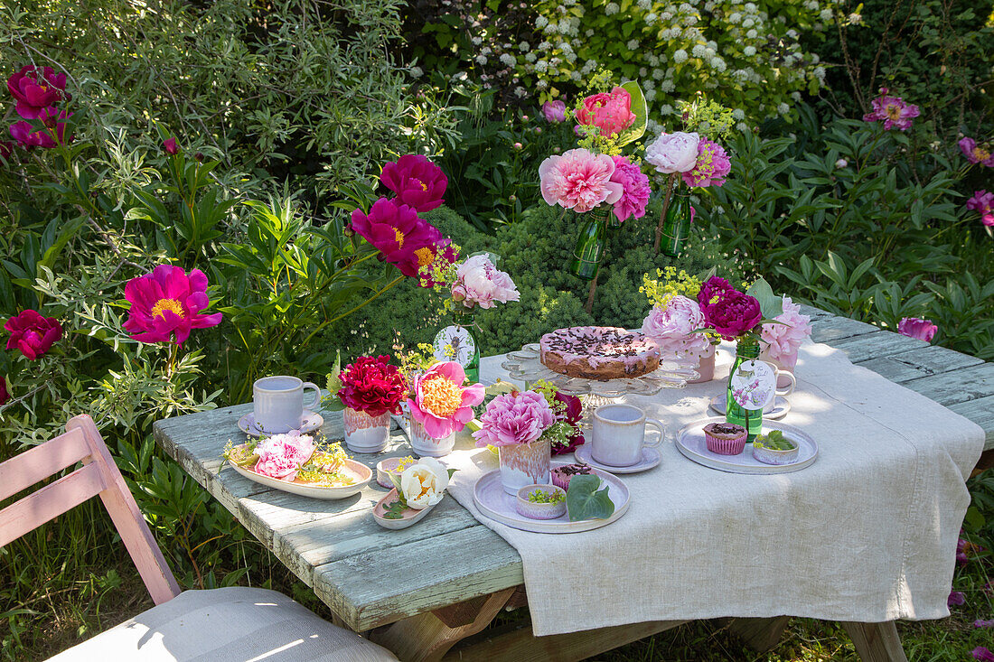 Summery coffee table in the garden with lush peony decoration