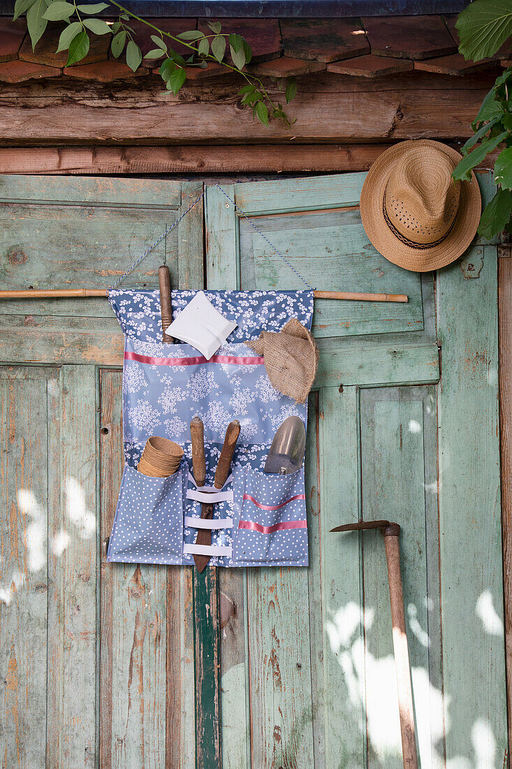 DIY organiser with garden tools attached to wooden shed