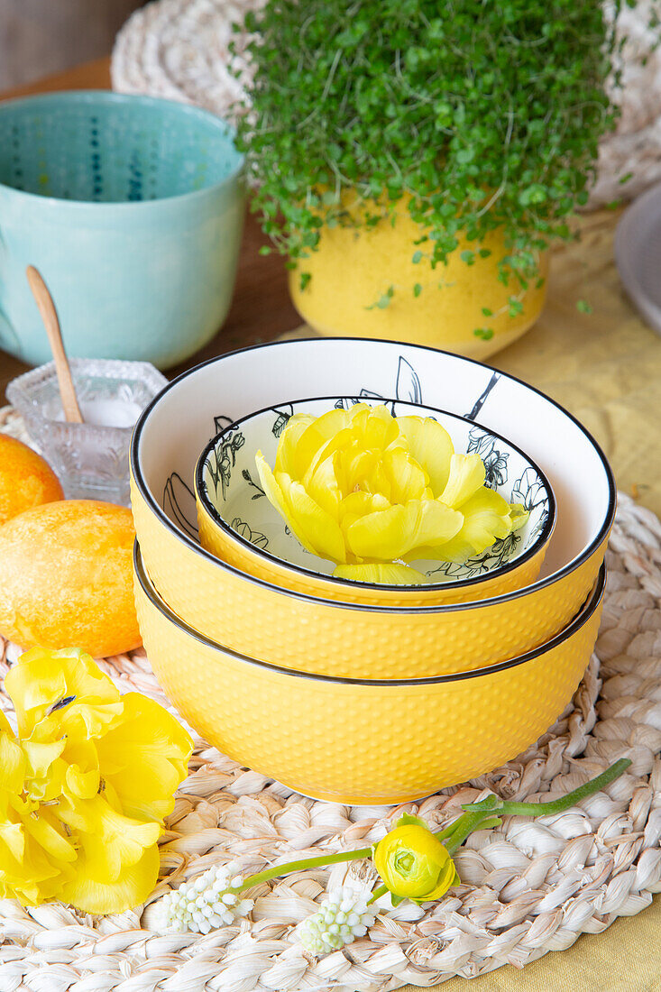 Yellow ceramic bowls with ranunculus on a woven placemat