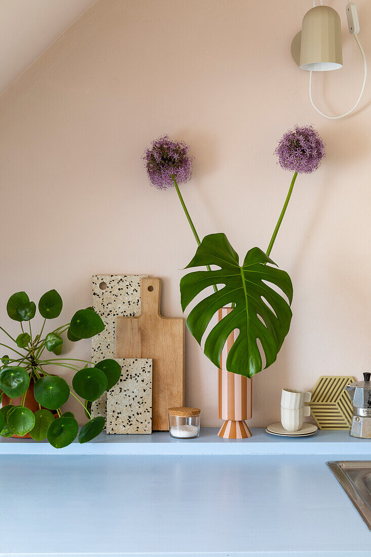 Dekorative Küchenecke mit Monstera-Blatt in Vase und Schneidebrettern