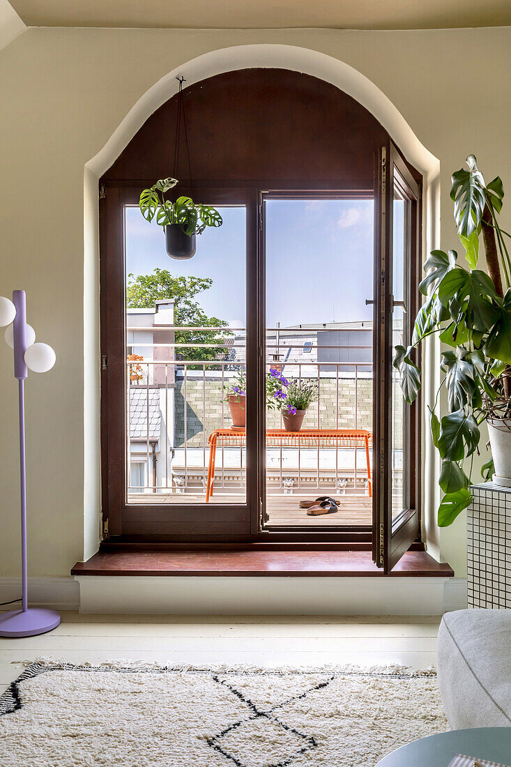 Balcony door with hanging plant and view of city balcony