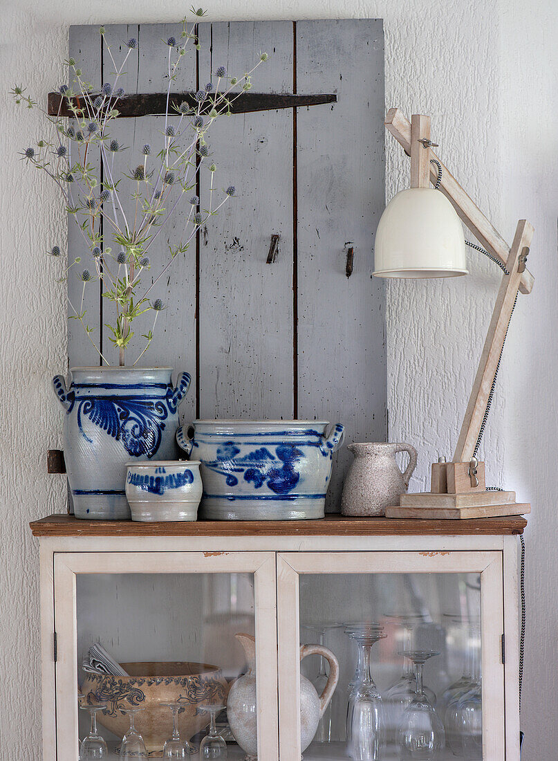 Vintage crockery cupboard, antique vessels and table lamp