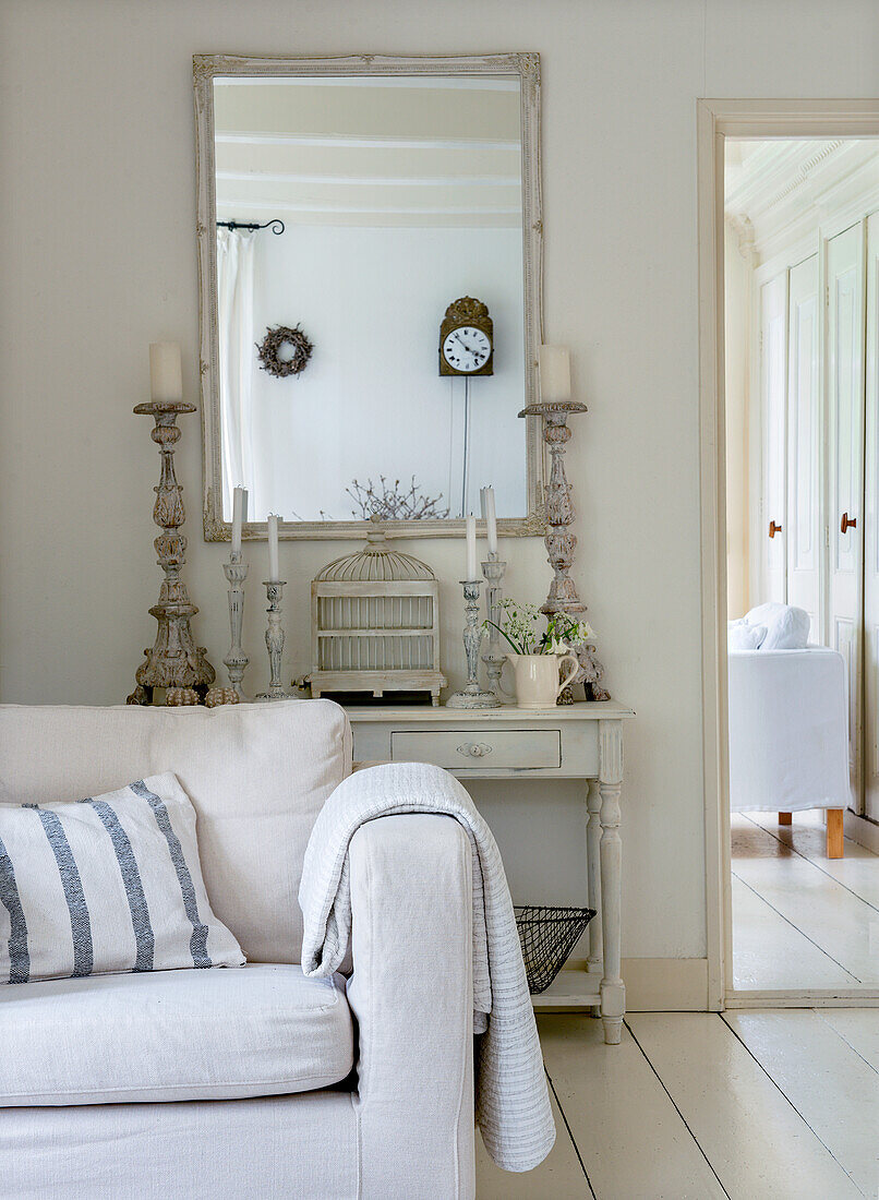 Bright vintage-style living room with antique mirror and candlesticks