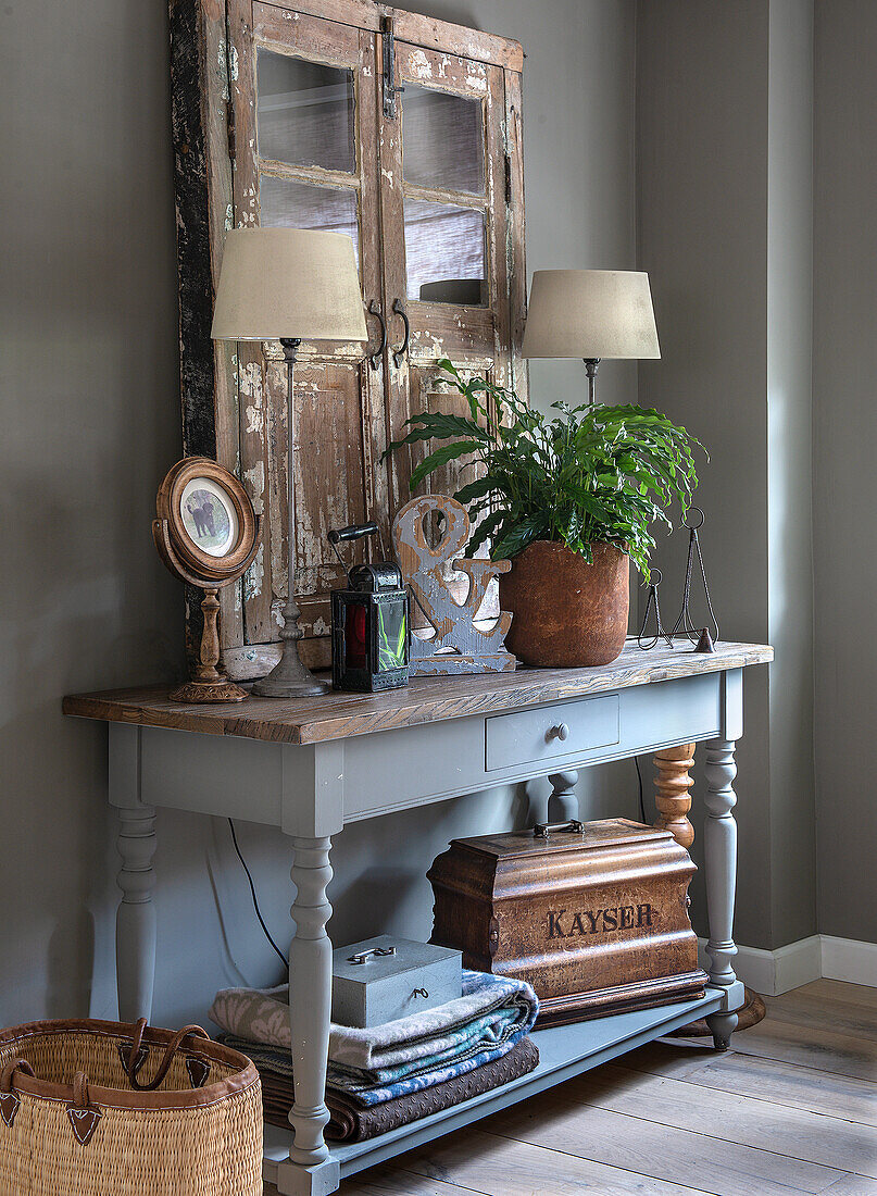 Vintage console table with houseplant and antique decorations