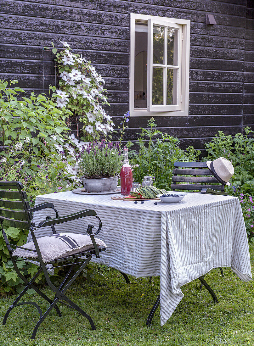 Gedeckter Gartentisch mit gestreifter Decke und Lavendel