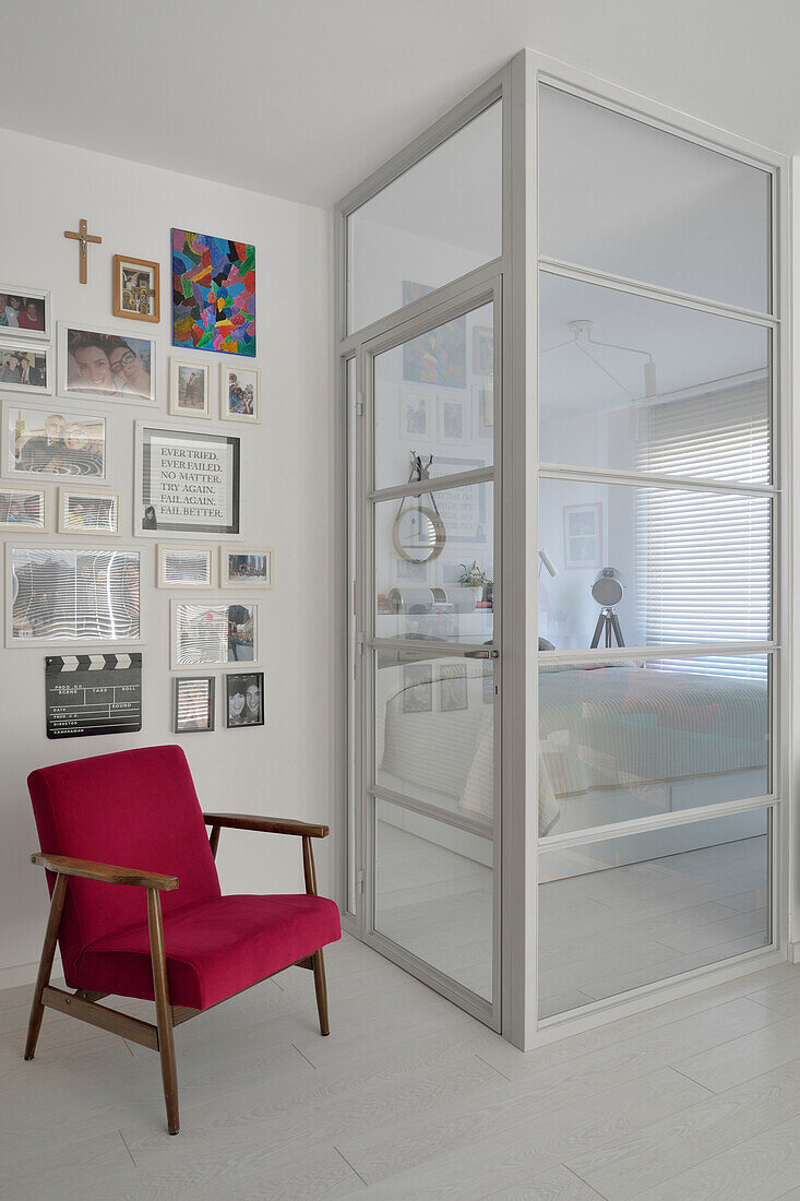 Roter Retro-Sessel, Bilder und Glastür mit Blick ins Schlafzimmer in Warschau