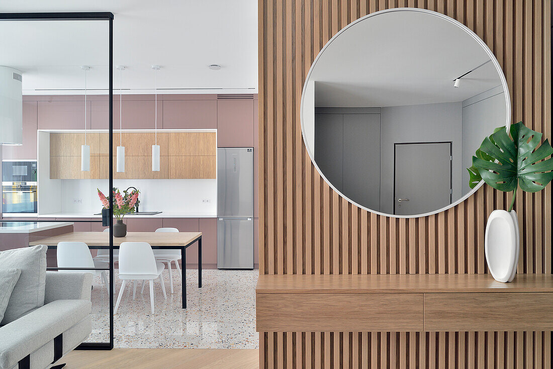 Moderne Wohnungseinrichtung mit rundem Wandspiegel und Holzvertäfelung
