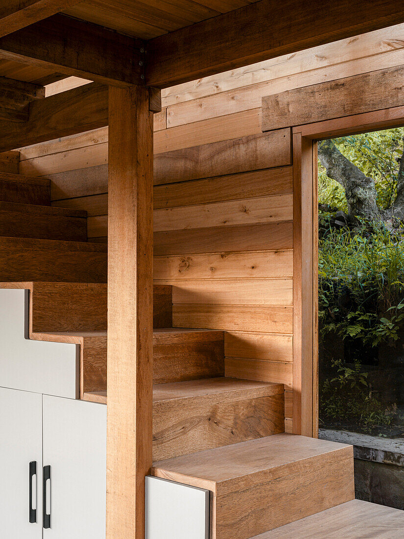 Wooden staircase with integrated storage space in a modern wooden house