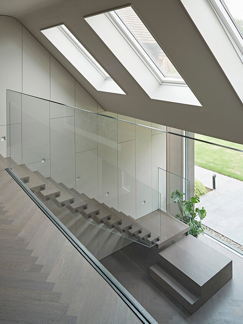 View from the upper floor into the entrance area, staircase with glass balustrade