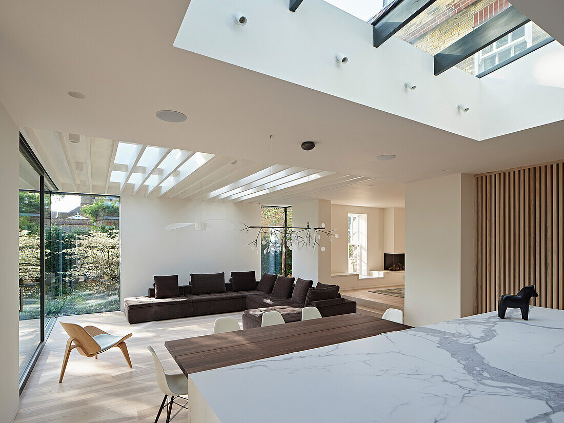 Open-plan living and dining area with skylights and garden view in London