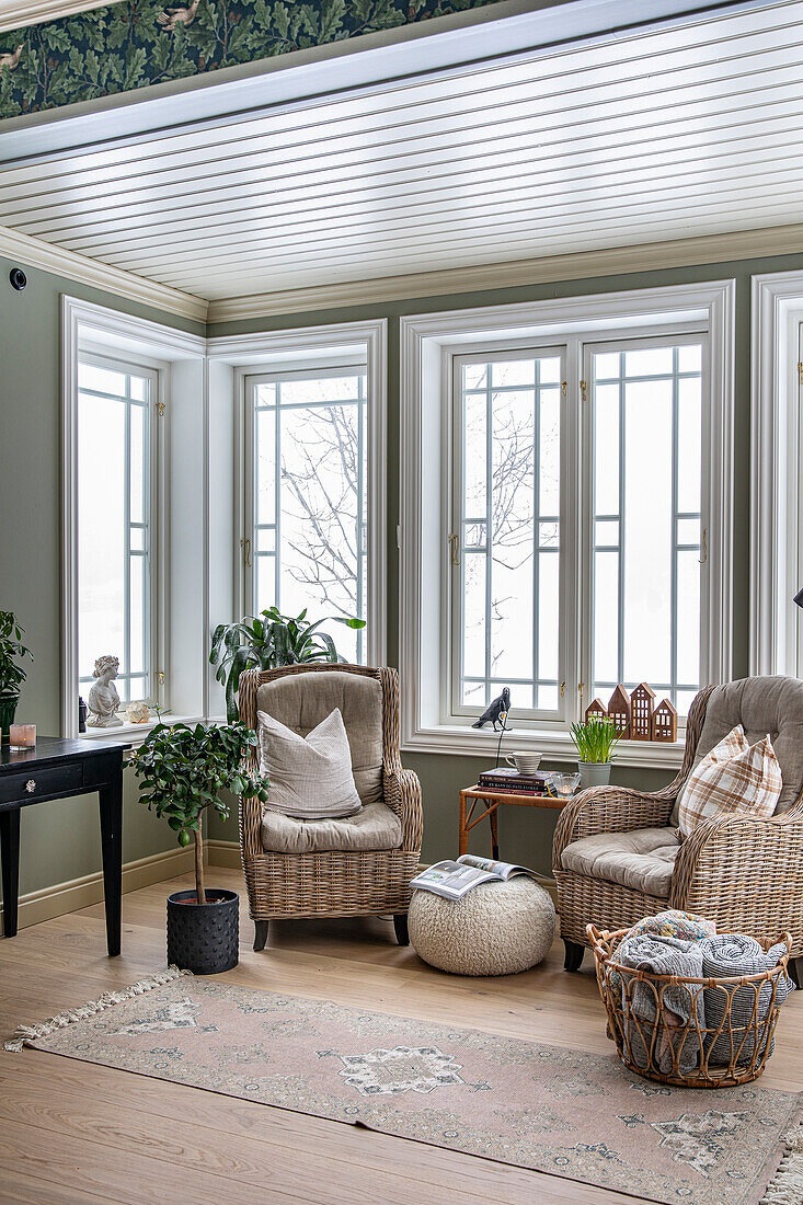 Reading corner with rattan armchairs and large windows