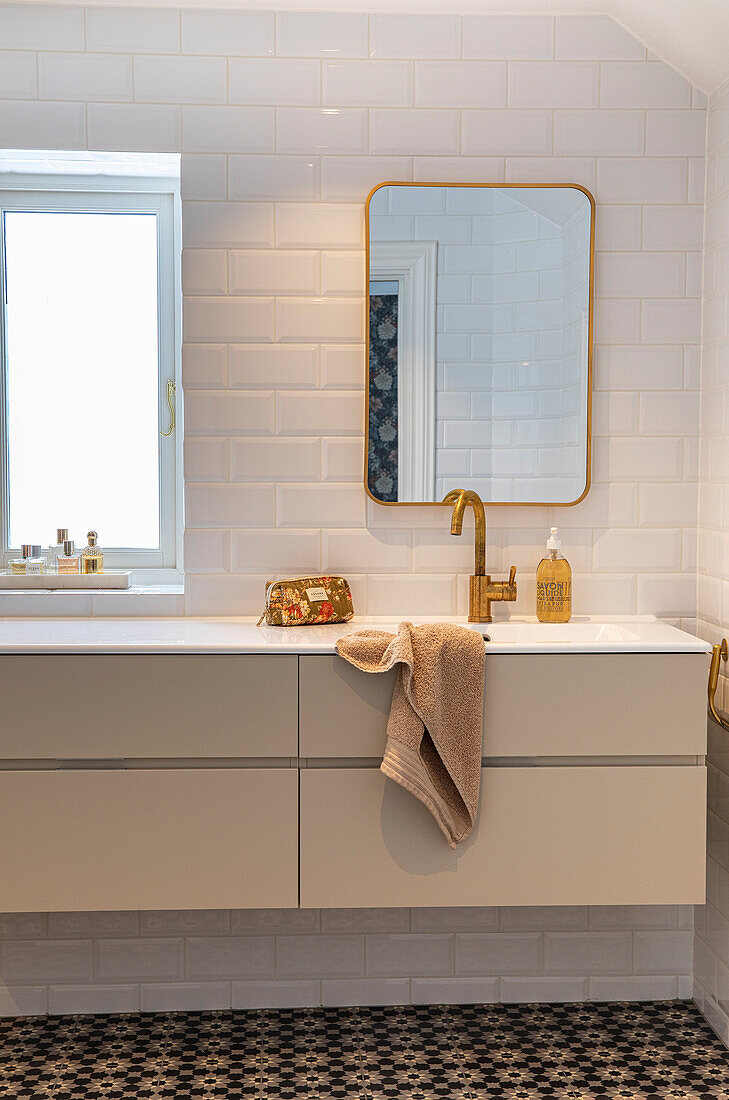 Modern bathroom with gold fittings and patterned tiled floor