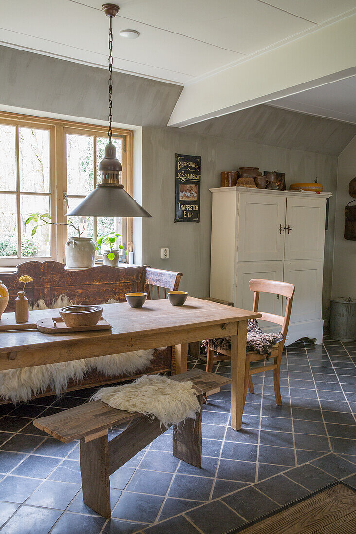 Rustikales Esszimmer mit Holzmöbeln und Fliesenboden