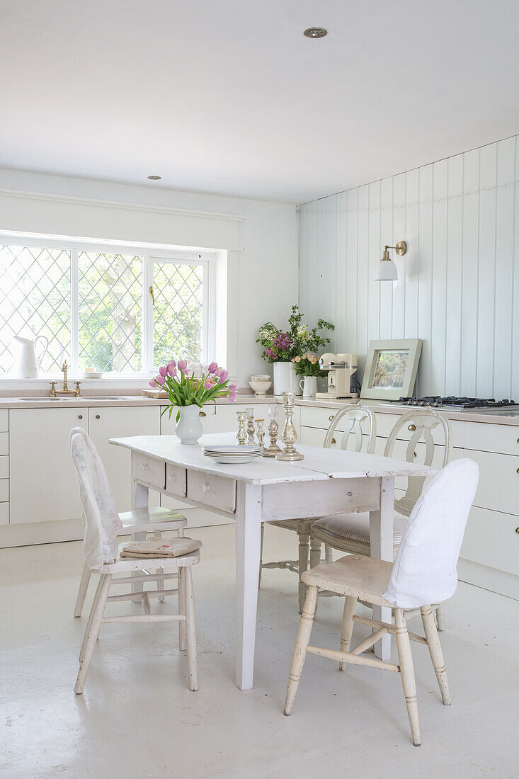 White country kitchen with dining area and fresh tulips