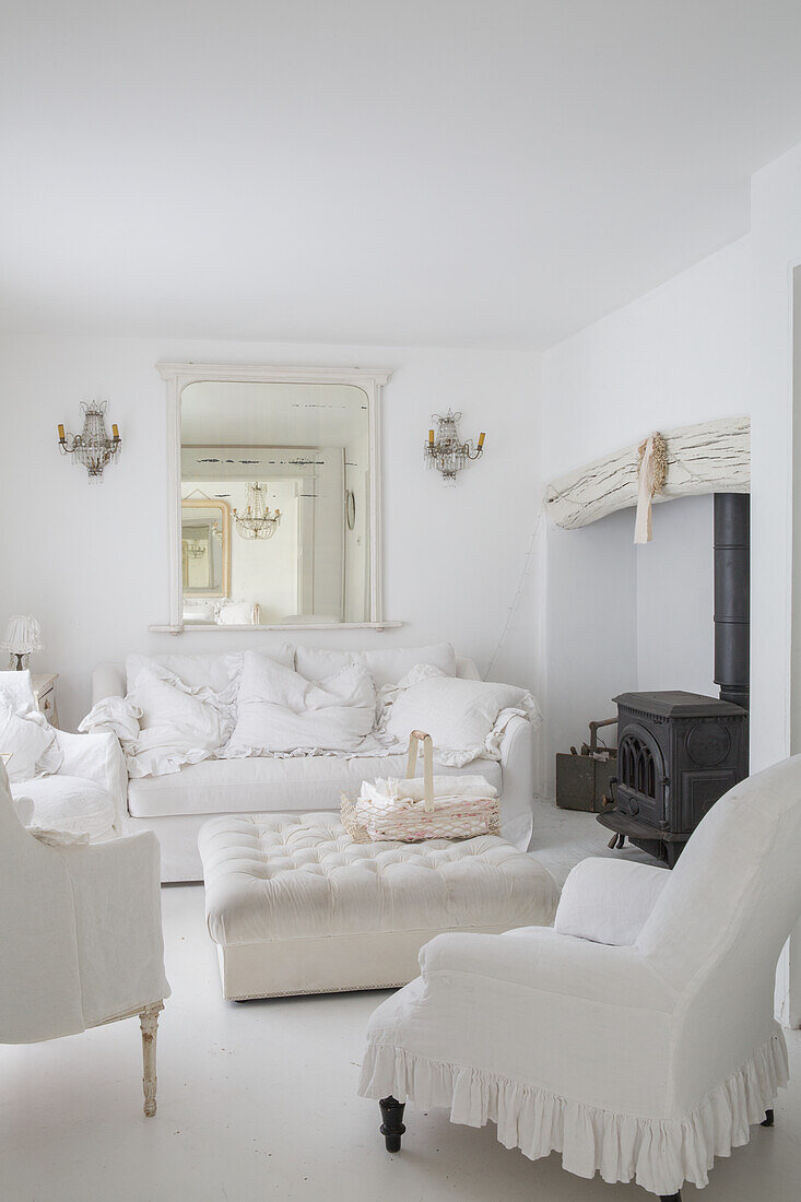 Living room in white with sofa, armchairs and wood-burning stove