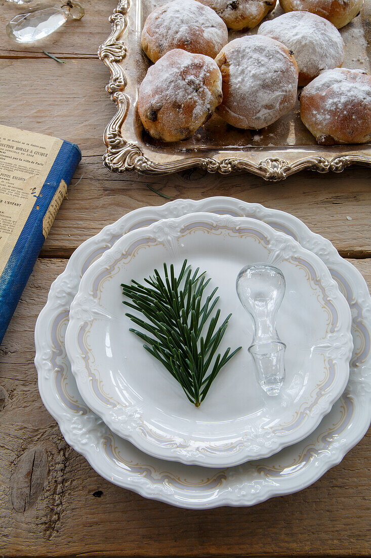 Teller mit Tannenzweig, Flaschenverschluss aus Glas und Tablett mit Gebäck