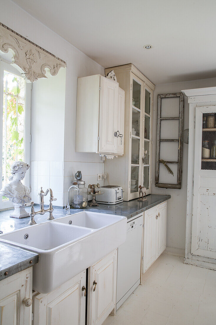 Country-style kitchen with white cabinets and stainless steel worktop