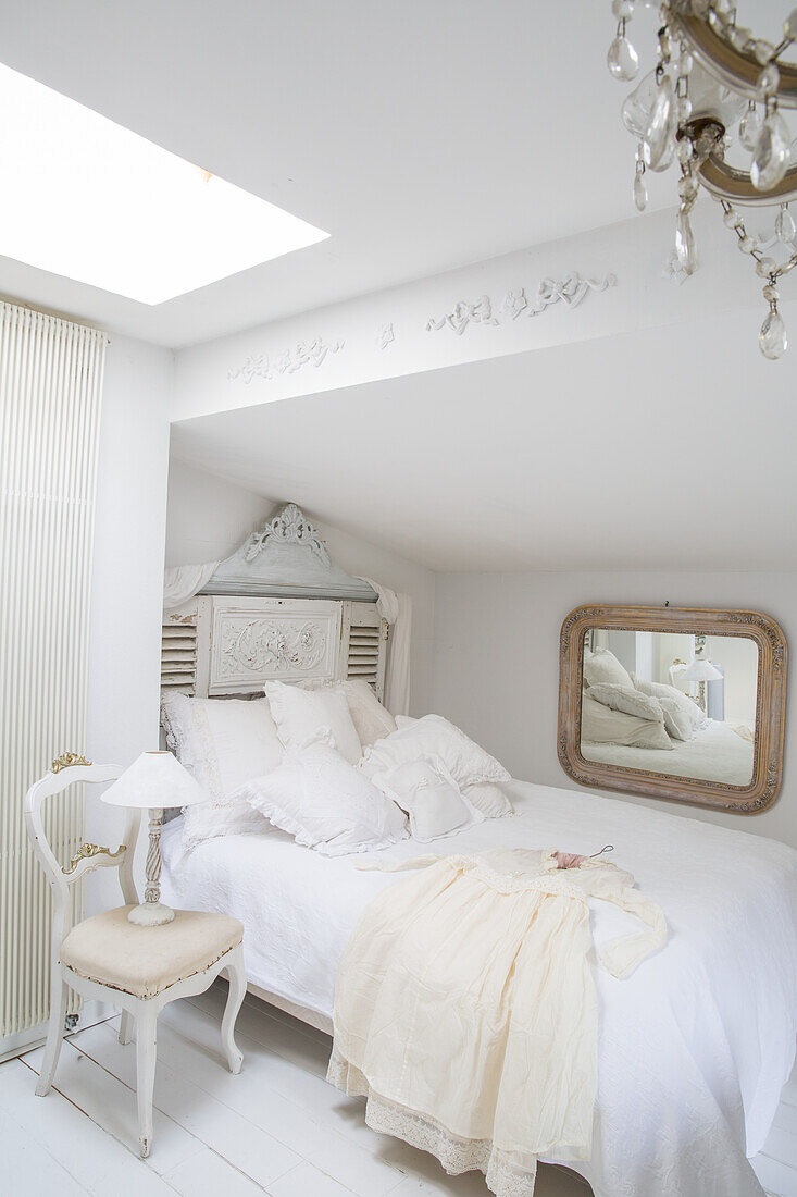 White bedroom with antique furniture and daylight window