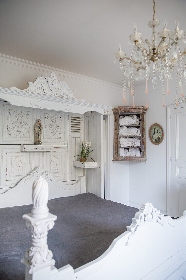 Baroque bedroom with white wooden four-poster bed and chandelier