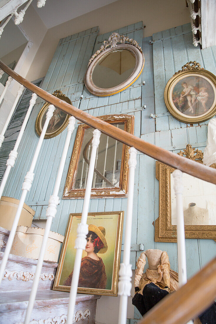 Vintage-Galeriewand mit gerahmten Porträts und Spiegeln im Treppenaufgang