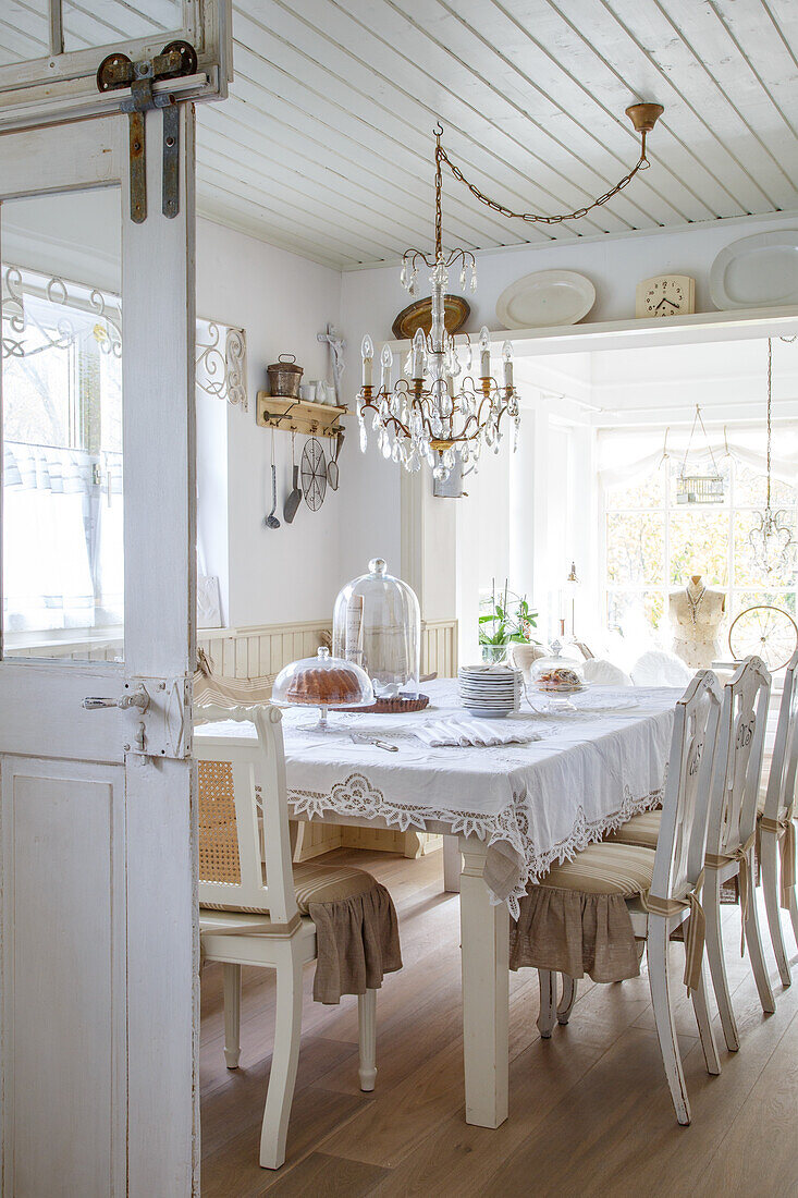 Esszimmer im Landhausstil mit Kronleuchter und gedecktem Tisch