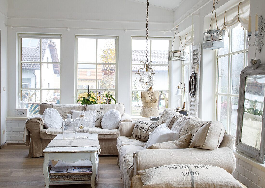 Country-style living room with beige sofas and chandelier