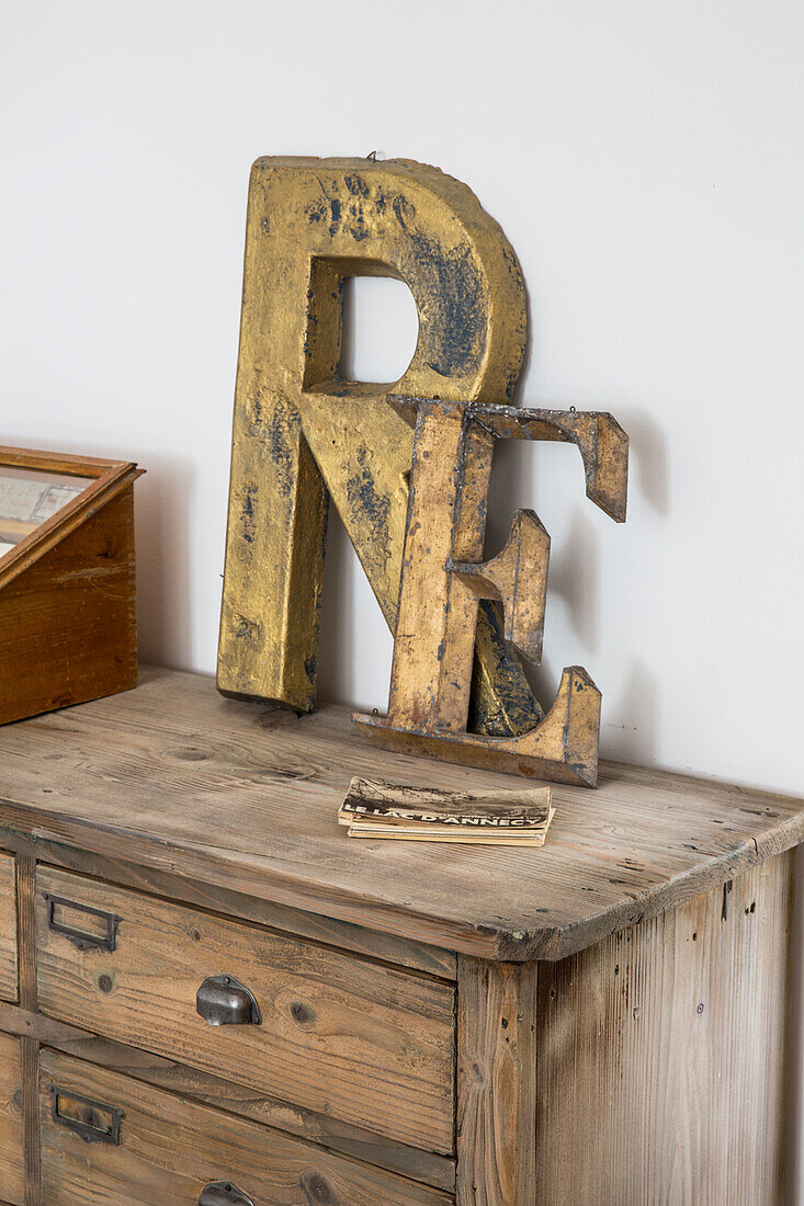 Wooden letters "RE" on rustic wooden cabinet