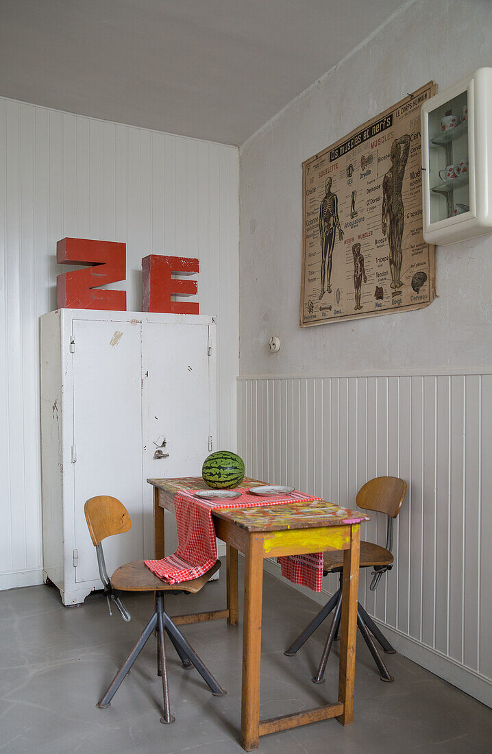 Vintage dining room with wooden table, metal chairs and white wall cabinet