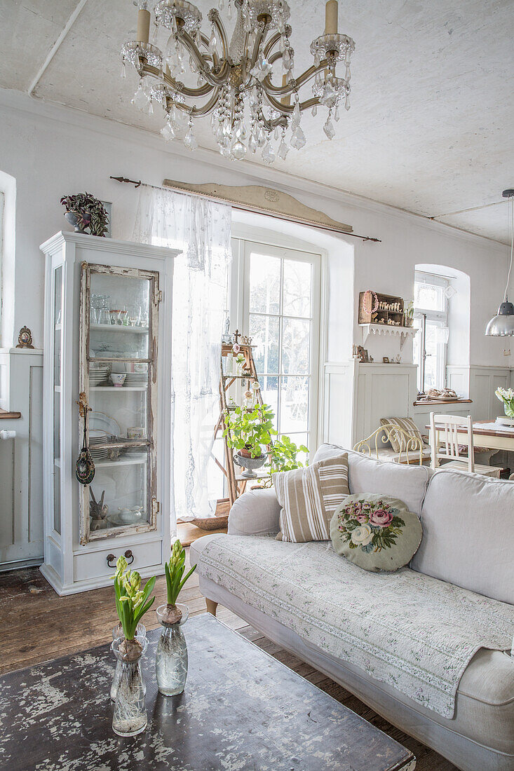 Open-plan living area with vintage furniture and crystal chandelier