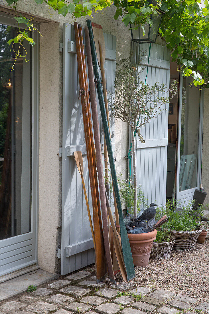 French country house style: Light blue shutters and various paddles in front of a house