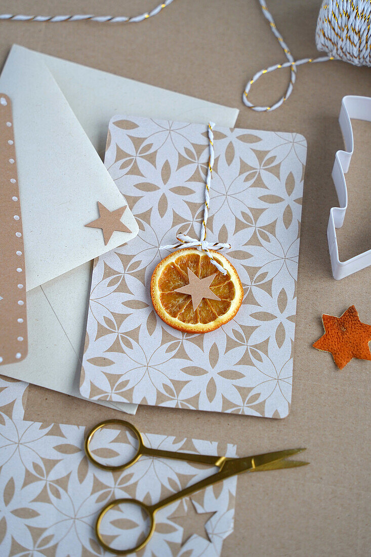 DIY-Weihnachtskarte mit getrockneter Orangenscheibe und Papierstern