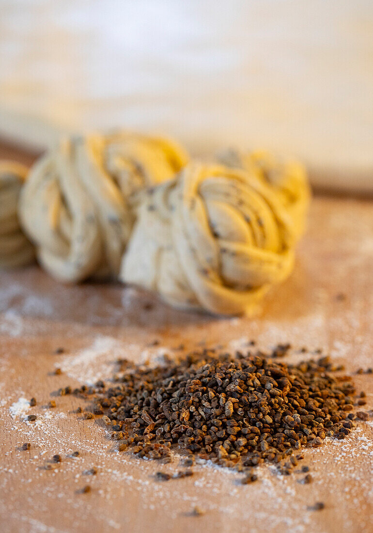 Dough balls and piles of seeds on a floured table