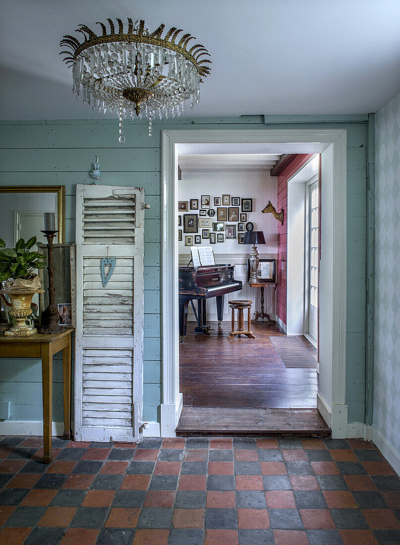 View through the hallway into a music room with grand piano and picture gallery on the wall