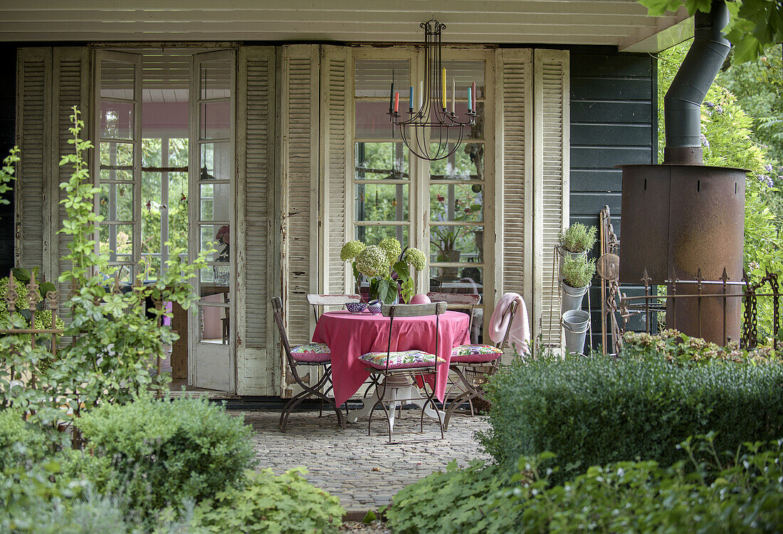 Sitzgelegenheit auf Gartenterrasse mit pinker Tischdecke