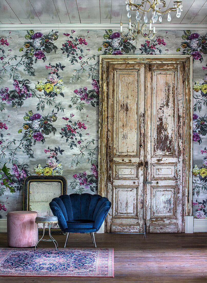 Vintage-Holztür und florale Tapete in buntem Wohnzimmer