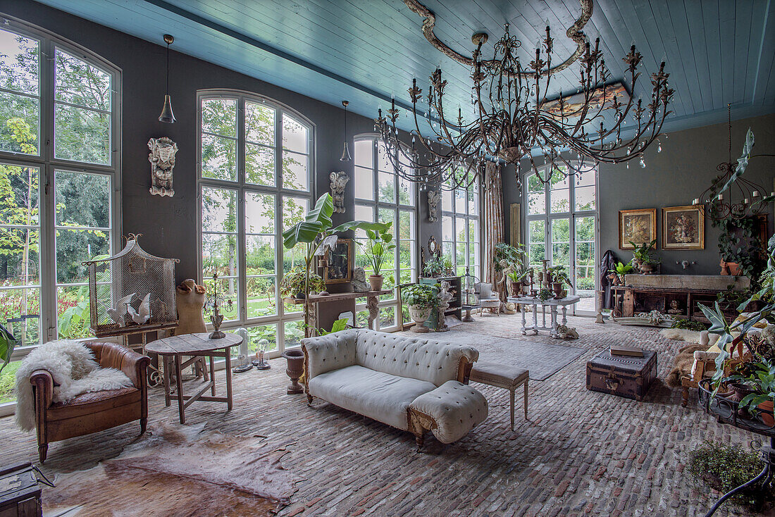 Large living room with high mullioned windows and antique furniture