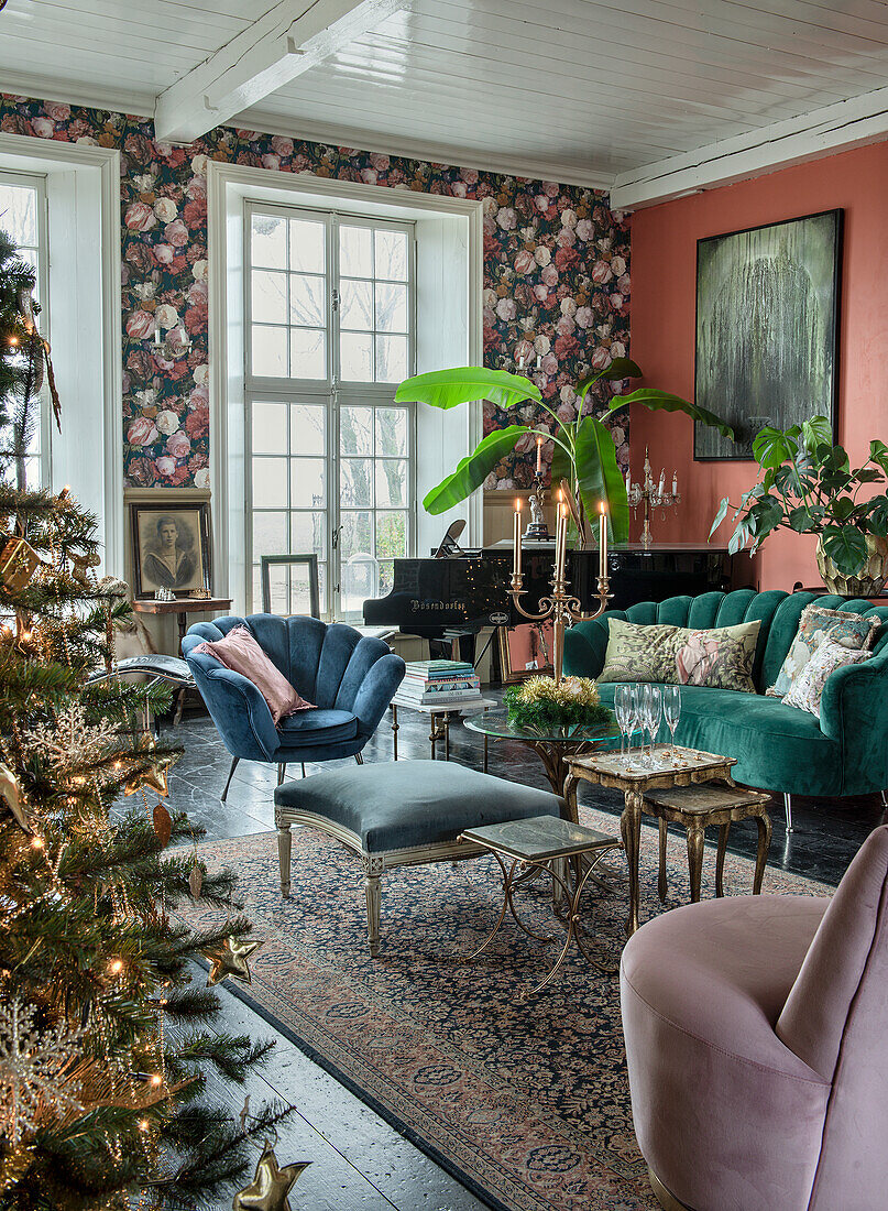 Vintage-style living room with floral wallpaper, velvet sofas and Christmas tree