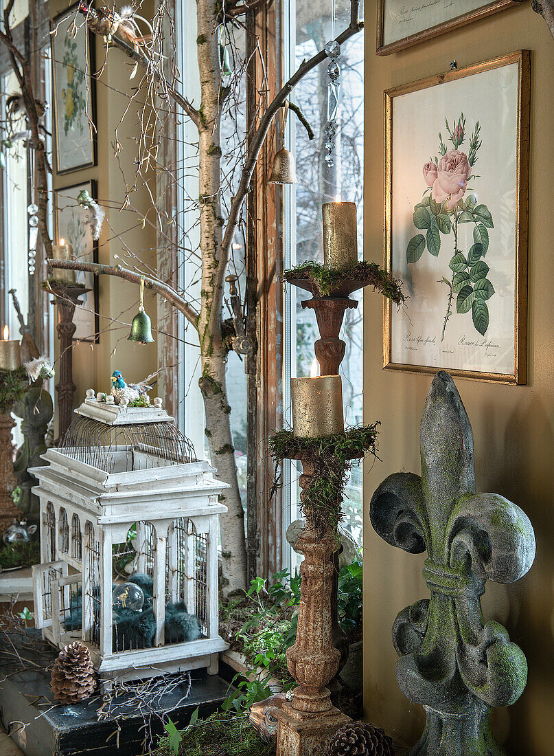 Rustic garden decoration with birdcage, candle holder and botanical wall pictures