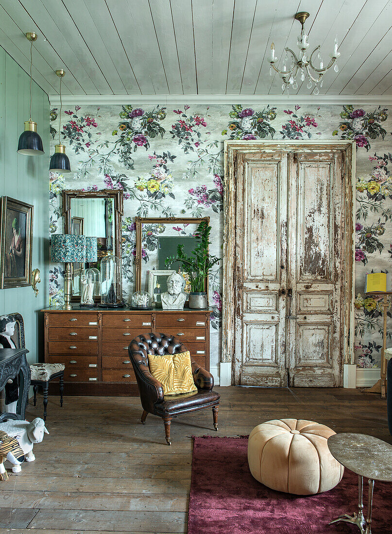 Country-style living room with floral wallpaper and antique wooden furniture