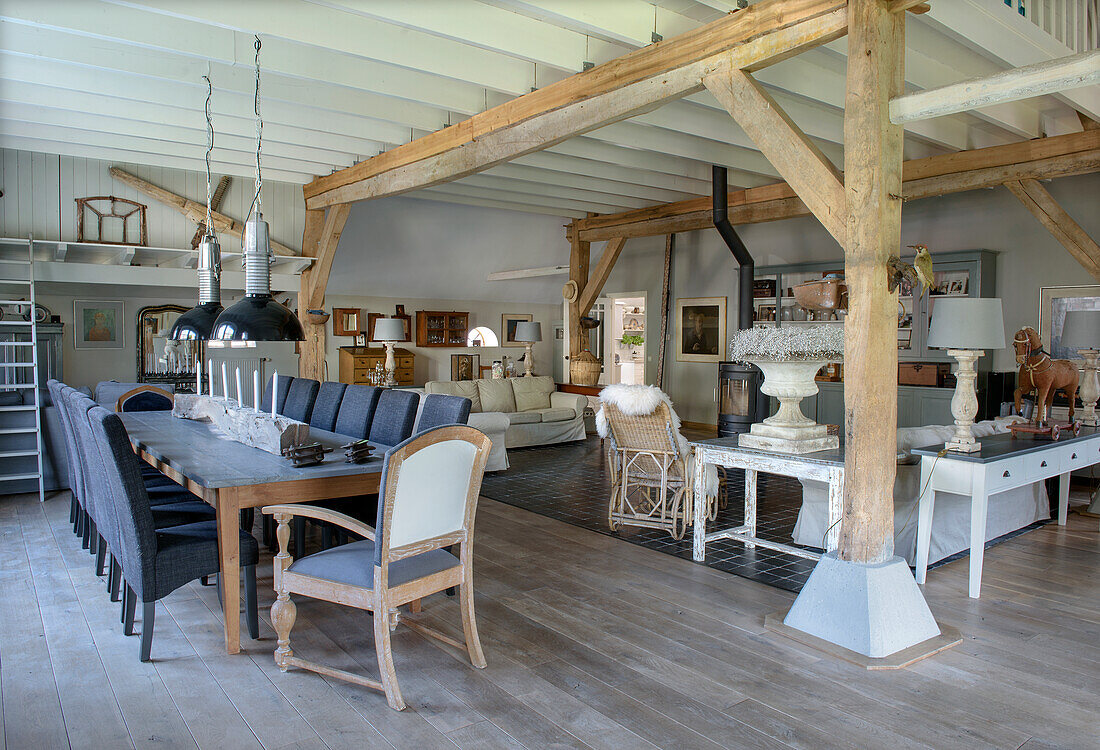 Spacious, rustic living and dining area with wooden beams and long dining table