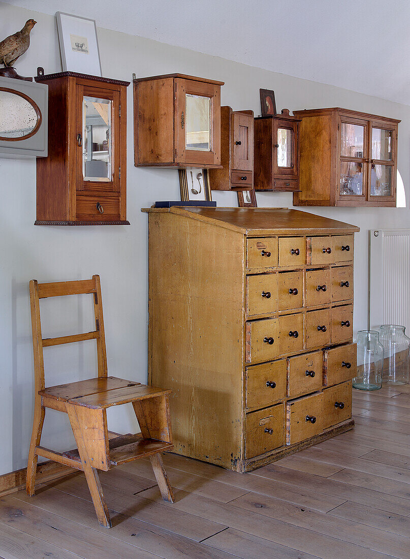 Antiker Holzschrank und Wandvitrinen in rustikalem Zimmer