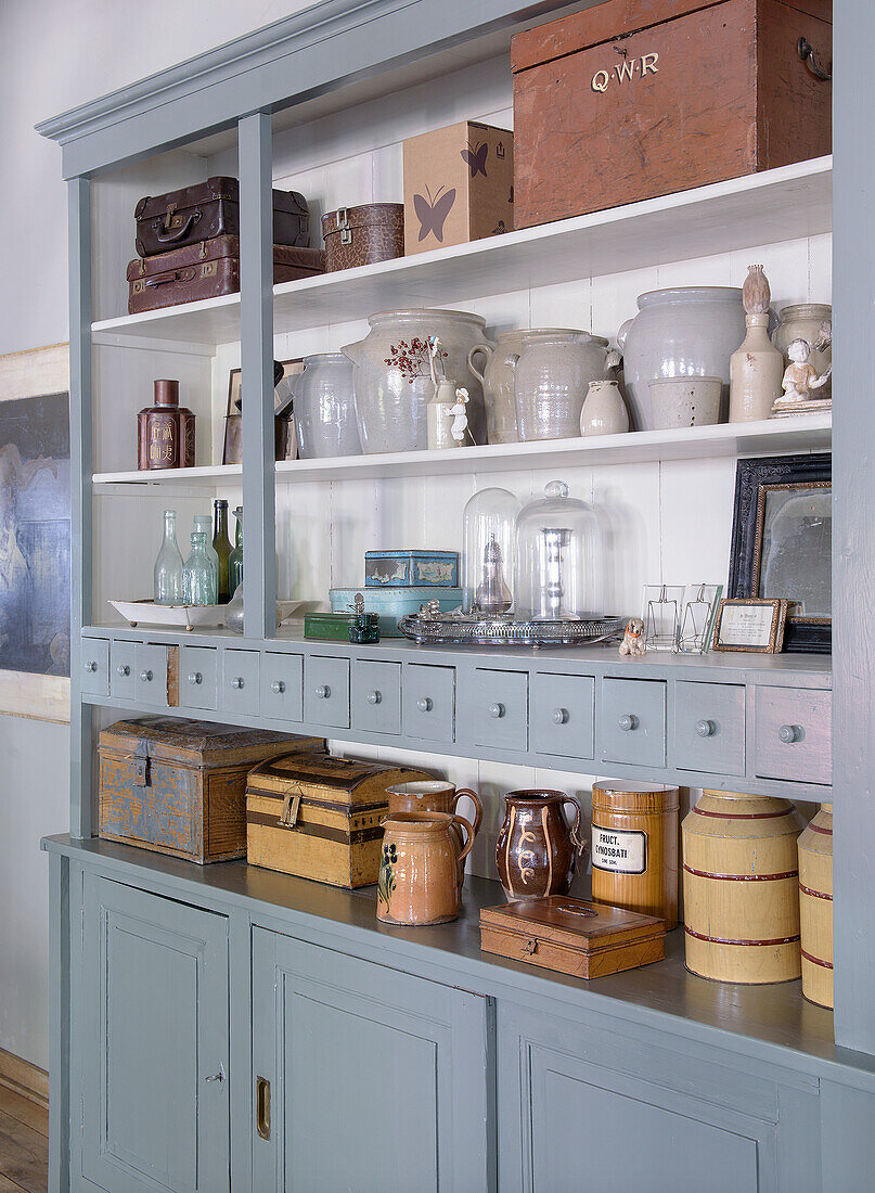 Vintage kitchen cabinet with ceramic jars, wooden boxes and glass objects