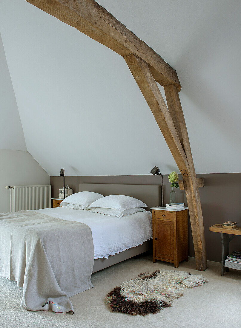 Bedroom with rustic wooden beams and carpeted floor