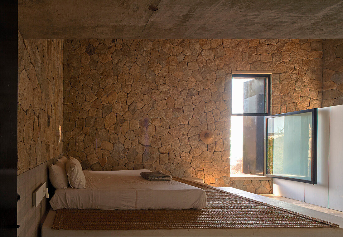 Bedroom with stone wall and natural lighting, Casa Cometa, Mexico